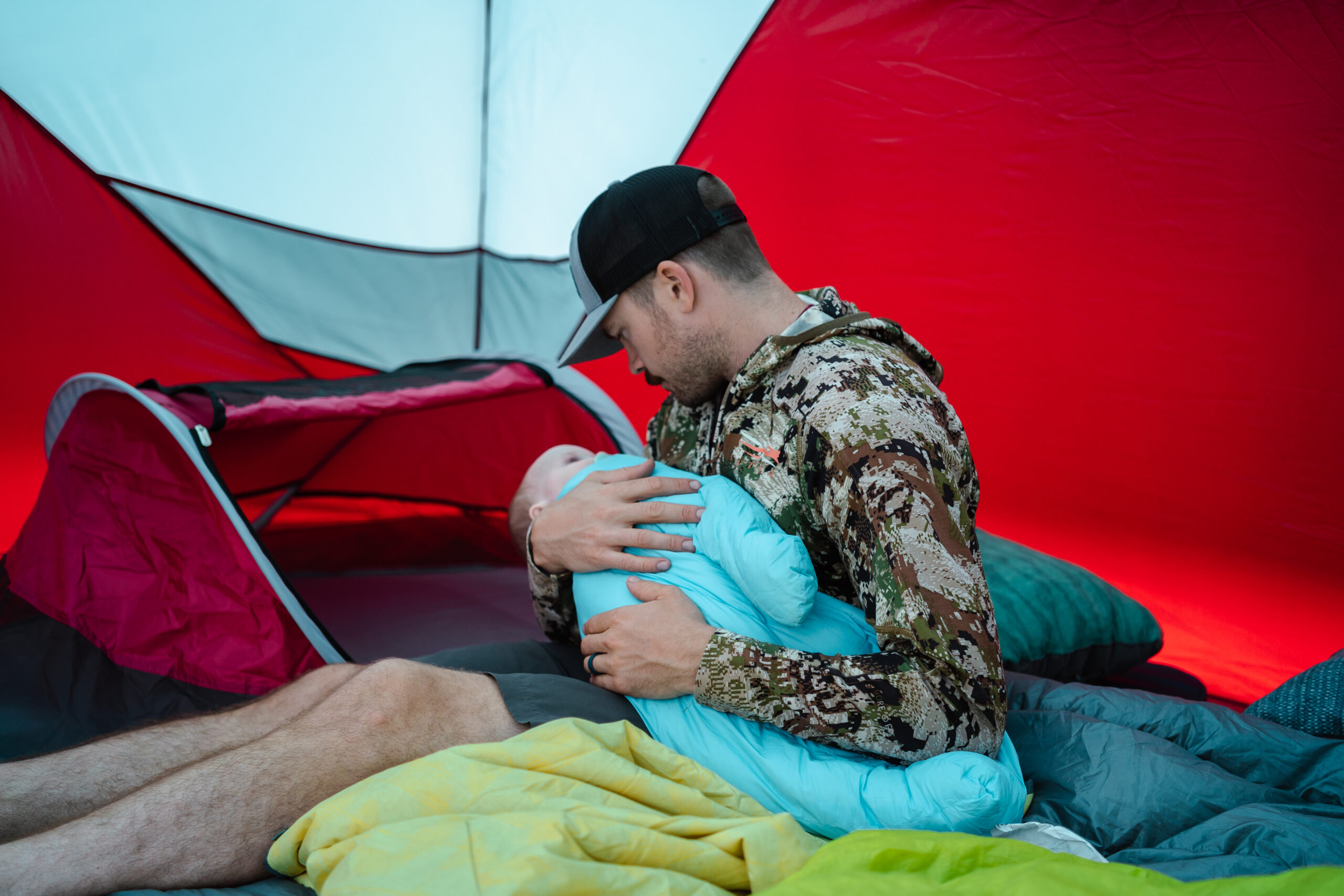 dad holds baby inside of tent rocking her to sleep 